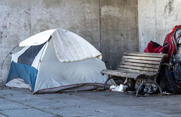 Tent in an urban area next to park bench