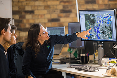 Photo of Floodmapp workers reviewing map image on PC monitor