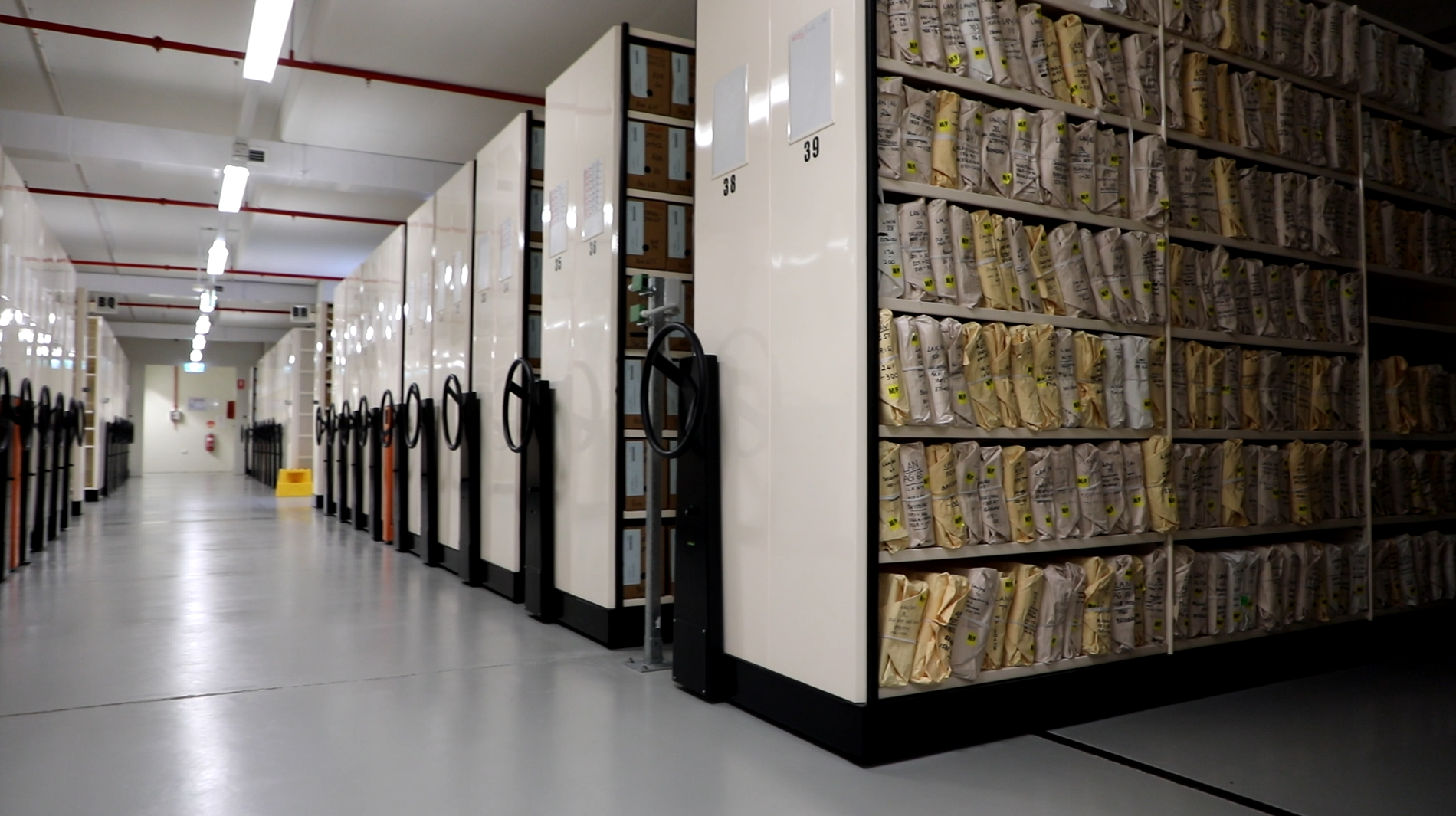 Photo of repository at Queensland State Archives showing shelves filled with wrapped bundles of records